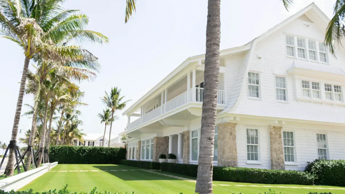 White coastal home surrounded by palm trees in Florida