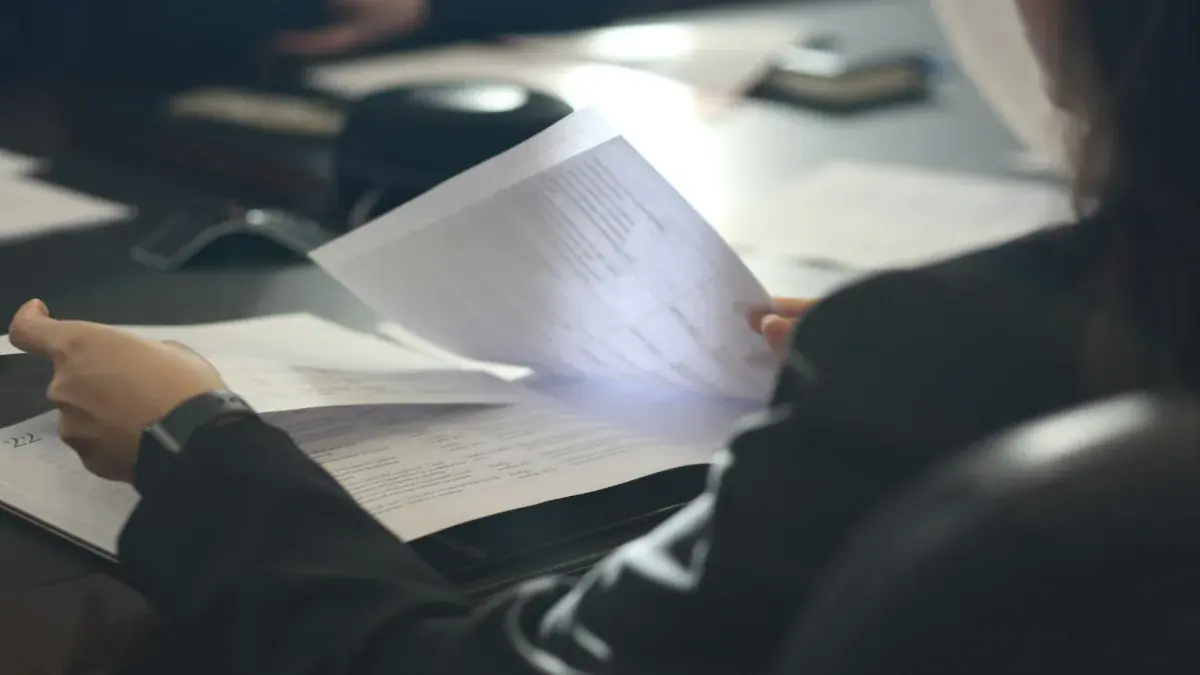 Person reading a printed document at a desk