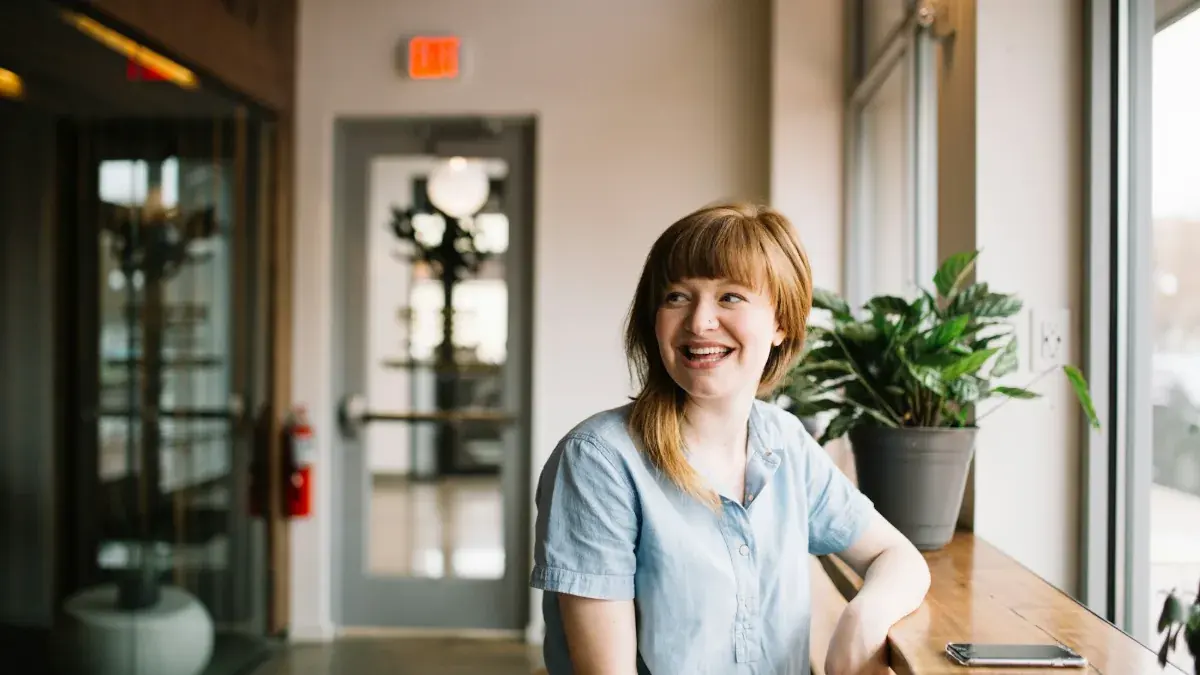 Smiling business owner sitting at a table in a bright office